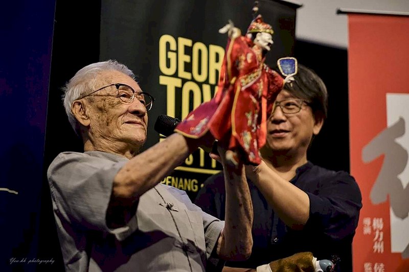 高齡89歲的台灣國寶級布袋戲藝師陳錫煌(左)畢生致力掌中戲演出與傳承,19日獲選為第23屆台北文化獎得主。圖為他參與馬來西亞2019喬治市藝術節示範演出。(台北市文化局提供)